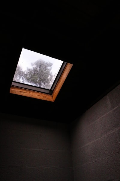 室内屋顶窗下的棕色混凝土墙